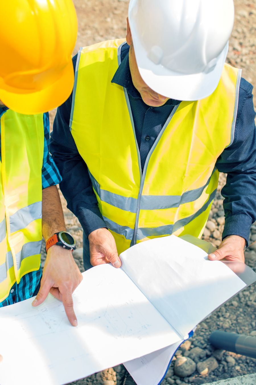 Bauarbeiter mit Helm schauen sich einen Plan an