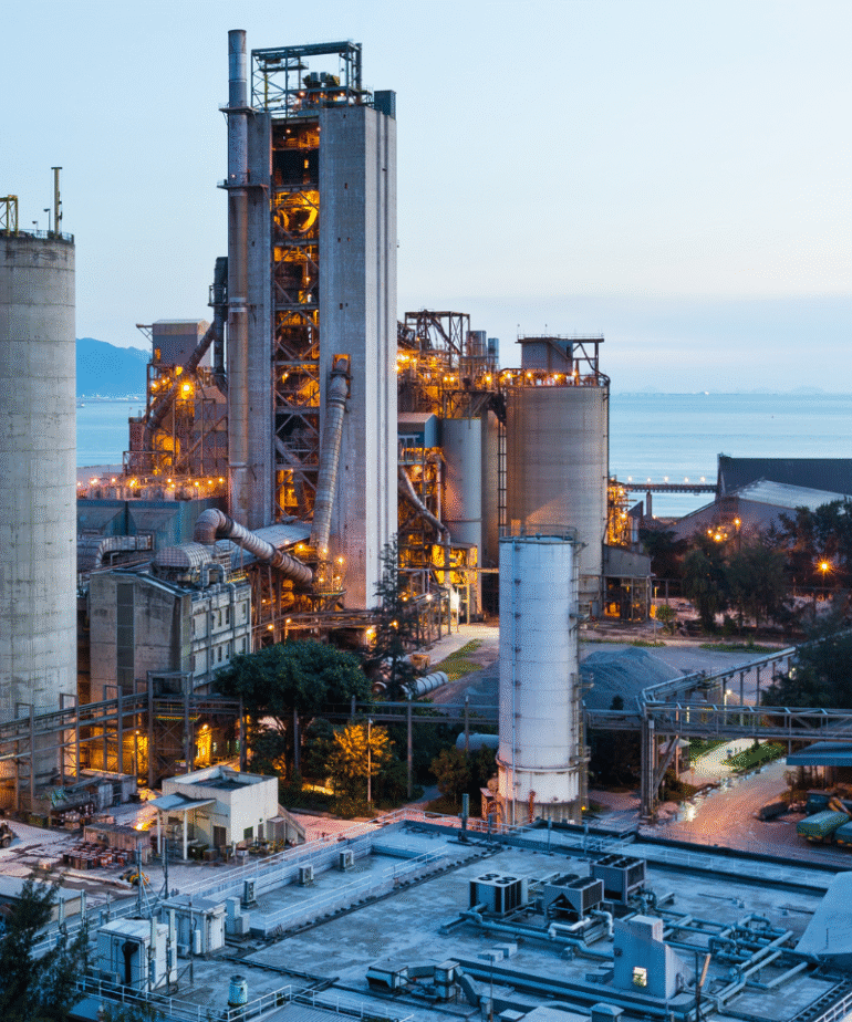 Industriewerk in der Dämmerung mit Licht am Meer