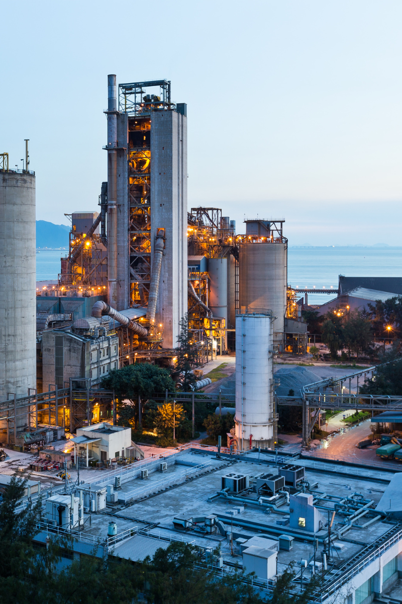 Industriewerk in der Dämmerung mit Licht am Meer