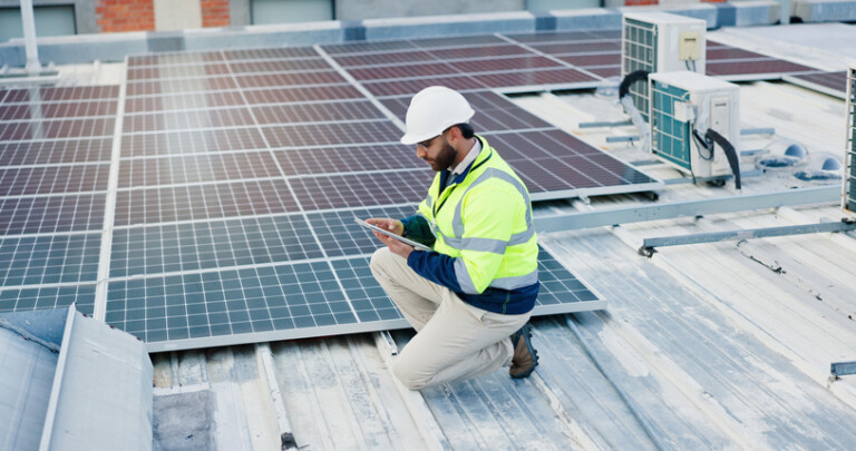 Technician, man and tablet for solar panels, energy saving and electricity or heating of eco friendly grid on rooftop. Engineering, digital technology and photovoltaic inspection for installation